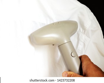 Man Ironing Shirt With Garment Steamer 