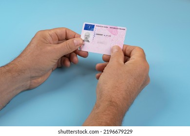 a man with an Italian driving license in the hands - Shutterstock ID 2196679229