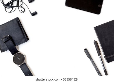 Man Items in all Black on a White Background Shot from Above with Cell Phone, Pens, Wallet, Watch, Notebook, and Headphones - Powered by Shutterstock