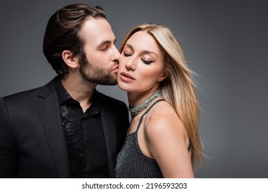 Man In Jacket Kissing Stylish Blonde Girlfriend Isolated On Grey