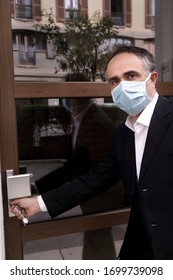 Man In Jacket With Protective Face Mask, Is Leaving His House Worriedly Because Of The Coronavirus