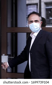 Man In Jacket With Protective Face Mask, Is Leaving His House Worriedly Because Of The Coronavirus