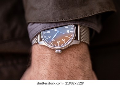 Man In Jacket With WWII Style Pilot Watch On Wrist At Sunset