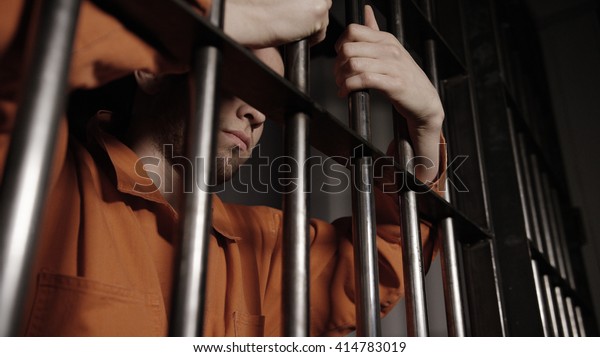 Man in\
jail behind bars - Caucasian young gang\
member