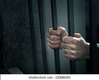 Man in jail hands close-up, depression and despair concept.