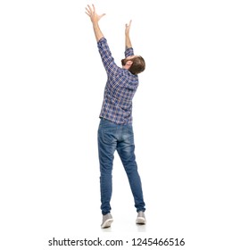A man in jeans hands up holding taking looking up on a white background. Isolation
