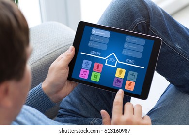 Man In Jeans Holding Tablet With App Smart Home On Screen