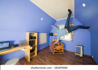 Man in jeans running on the ceiling upside down at inverted house