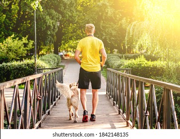 Man Jogging Across Bridge With Dog