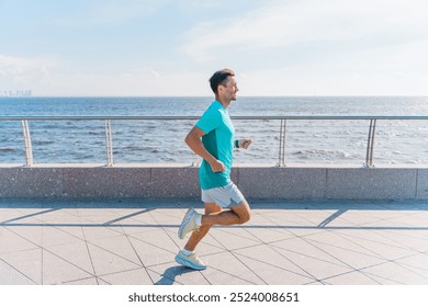 Man Jogging Along a Coastal Walkway With a Scenic View of the Ocean on a Sunny Day - Powered by Shutterstock