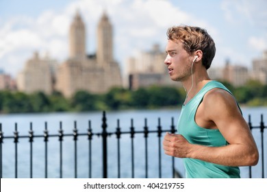 Man Jogging In Manhattan Central Park During Summer Male Caucasian Runner Running In New York City Along The Lake With View On Skyscrapers Background. New Yorker Living A Healthy And Fit Lifestyle.
