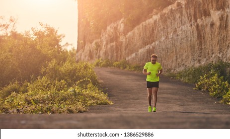 Man Jogging On A Downhill / Uphill In Suburb Mountain Road.