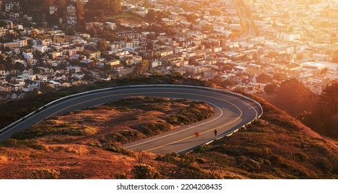 Man Joking On Curved Road On Twin Peaks Blvd Road With Blurry Aerial View Of Misty City Of San Francisco, California, USA At Sunrise.