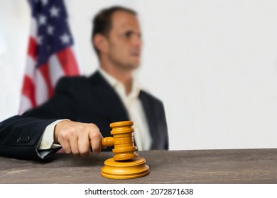 Man Judge Holding Wooden Gavel On Court Room With Usa Flag In Background.