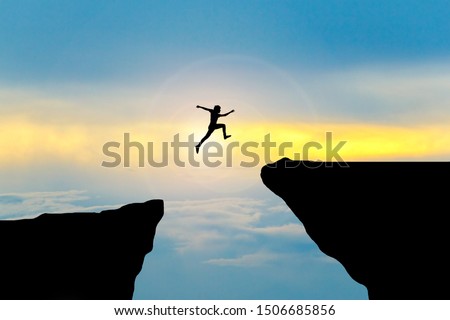 Man jump through the gap between hill.man jumping over cliff