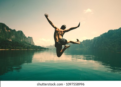 Man Jumping With Joy By A Lake