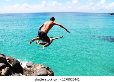 Man Jumping Off Cliff Into The Ocean. Summer Fun Lifestyle. Diving Cliff Ocean 