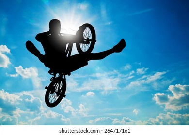 Man jumping on bmx bike performing a trick against sunny sky. Extreme sport - Powered by Shutterstock