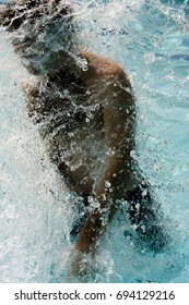 Man Jumping Out Of Water With Lots Of Spash In Swimming Pool