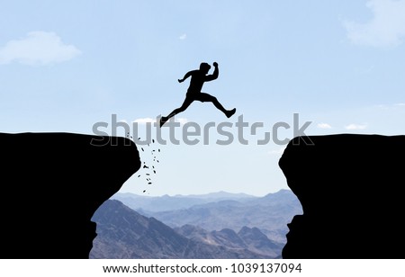 Man jumping over abyss.