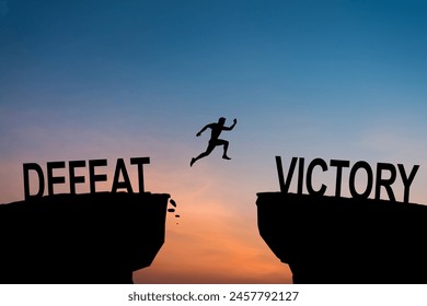 Man jumping over precipice between two rocky mountains at sunset. Freedom, risk, challenge, success. With the words Victory and defeat. - Powered by Shutterstock