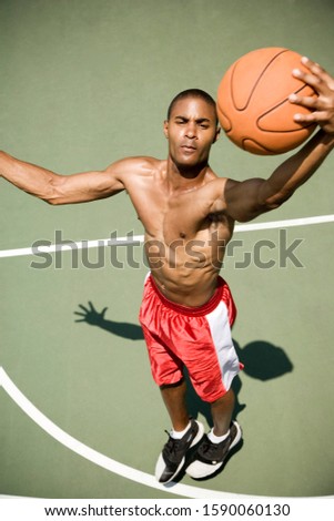 Man jumping and shooting on an outdoor basketball court