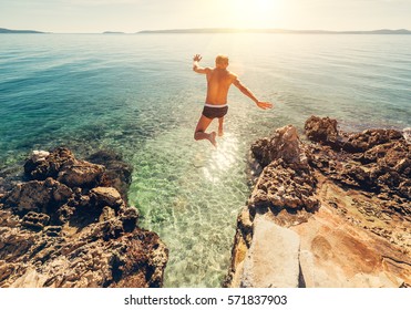Man jumps in blue sea lagoon water