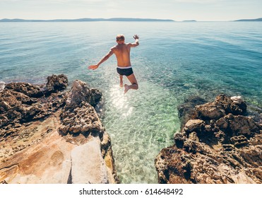 Man Jumps In Blue Sea Lagoon Water