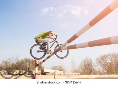 Man jumps over the barrier on stunt bike.
Such jump on a bike called the Bunny Hop.
