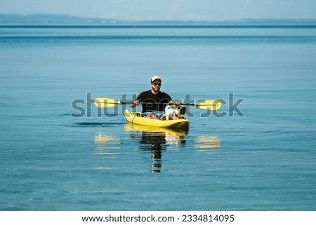 Man in kayak with his pug dog. Dog in boat. Summer fun pug kayak. Relaxing summer time with your pet. Funtime with dog. Cute pug in kayak. Pug paddle. Yellow kayak, yellow boat