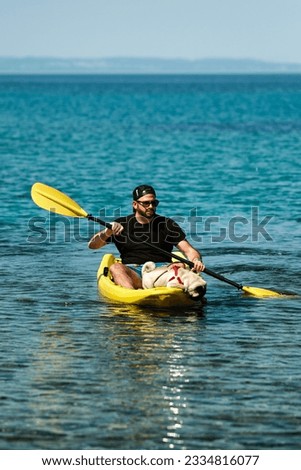 Man in kayak with his pug dog. Dog in boat. Summer fun pug kayak. Relaxing summer time with your pet. Funtime with dog. Cute pug in kayak. Pug paddle. Yellow kayak, yellow boat. Dog explorer