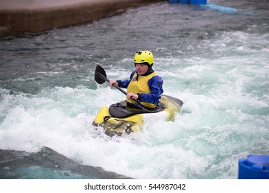 Man In Kayak Paddling Upstream In Fast Flowing Water