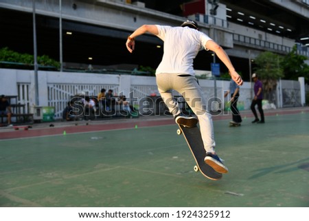 A man kicks a skateboard in the air