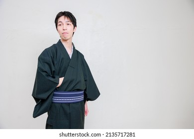 A man in a kimono who puts his right hand in his pocket