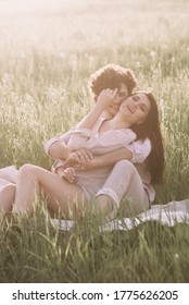 Man kisses his girlfriend sitting on a grass. Happiness concept - Shutterstock ID 1775626205