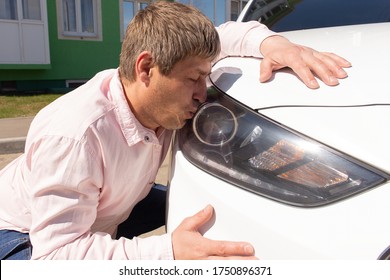 the Man kisses his new car in the headlight