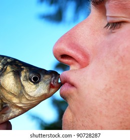 Man kissing the first fish he caught to ensure good luck for all the season