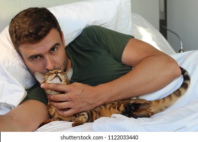 Man Kissing His Cat In Bed 