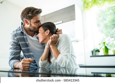 Man Kissing On Woman Forehead At Home