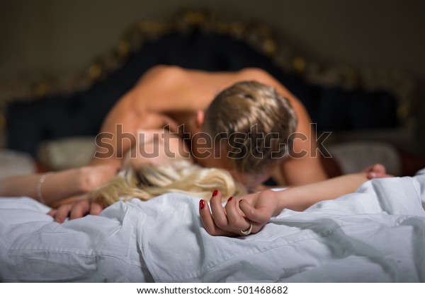 ベッドで仰向けに寝ている間に女の首にキスをする男 の写真素材 今すぐ編集