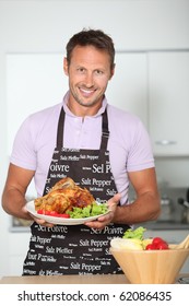 Man In Kitchen With Apron Cooking Chicken