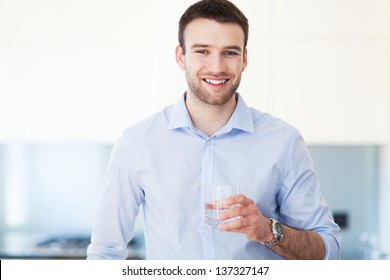 Man In Kitchen With Glass Of Water