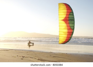 A man kite buggying at the beach at sunset - Powered by Shutterstock