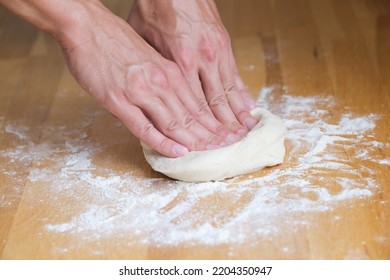 Man Kneading Dough And Making Pizza At Home