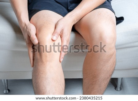 Man with knee pain, he puts his hand on his knee, pain point from osteoarthritis and osteoarthritis, medical concept and treatment