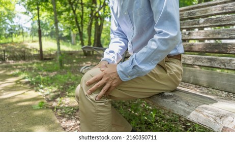 A man with knee pain.Sit on a park bench.