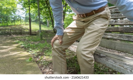A man with knee pain.Sit on a park bench.