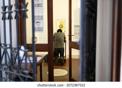 Man Kneeling In Front Of The Holy Sacrament