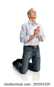 Man Kneeling And Praying To God.