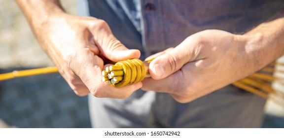 A Man Knitting His Easter Whip From A Rod